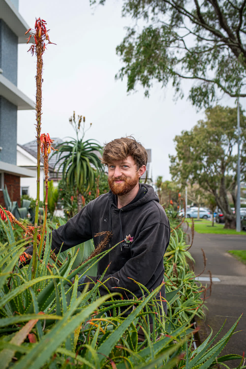 Smiling gardener standing in bushes